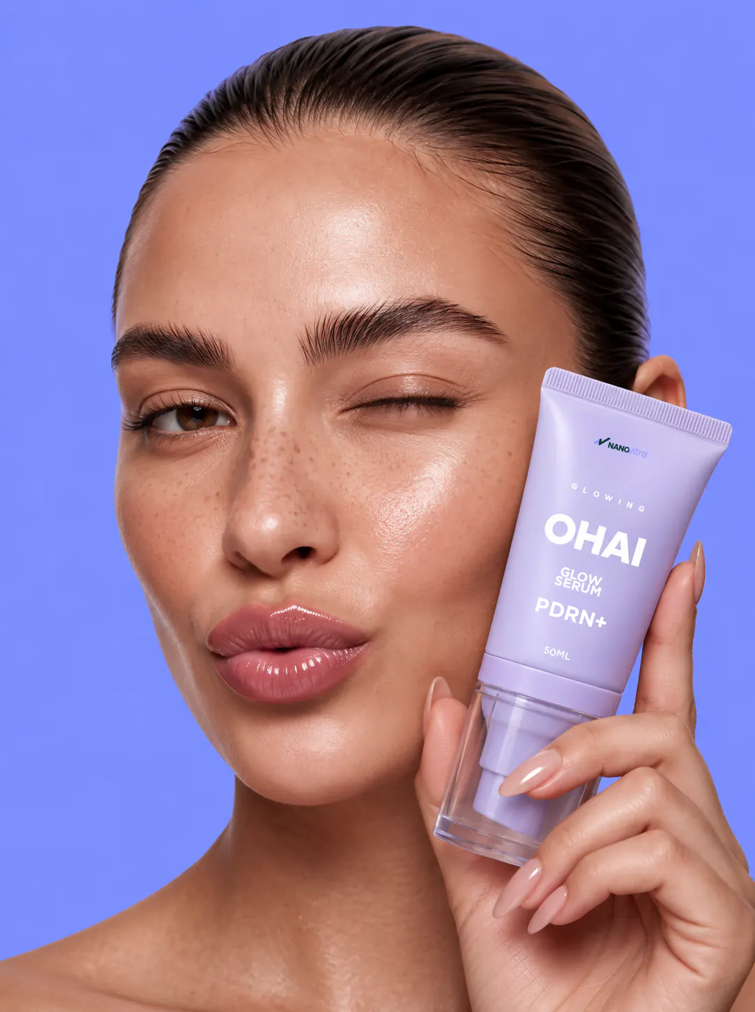 Model winking while holding OHAI PDRN+ Glow Serum by NANOvitra to her cheek